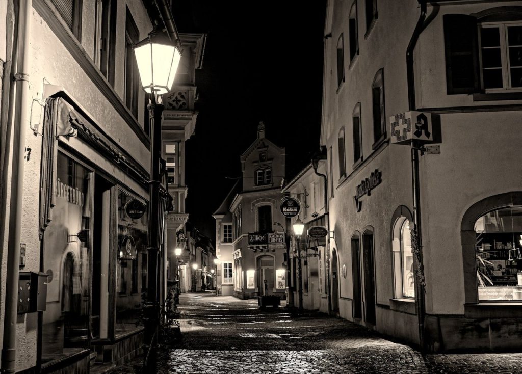 Em Hunter’s Moon, ouvir e observar podem ser tão importantes quanto fugir Rua histórica de paralelepípedos, com edifícios antigos iluminados durante a noite.